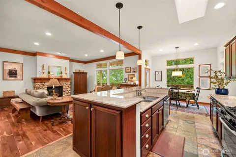 a kitchen with stainless steel appliances granite countertop table chairs and a large window