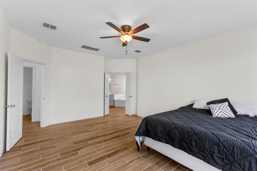 2700 Hereford Road Denton, TX 76210 - Photo 16 of 36 Spacious bedroom featuring wood-finish tile flooring and a ceiling fan with integrated lighting