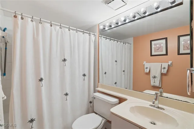 a bathroom with a sink mirror and toilet