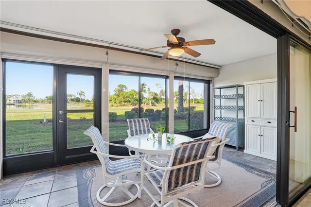 a dining room with furniture water view and a floor to ceiling window