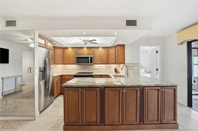 a kitchen with stainless steel appliances granite countertop a sink and a refrigerator