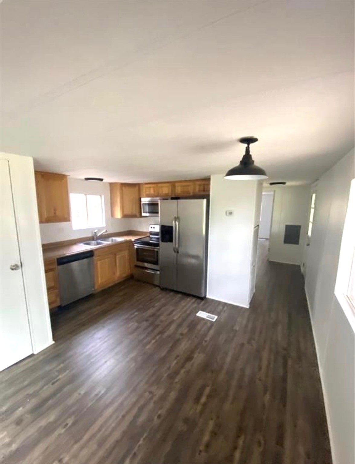 a view of a kitchen with a sink stove cabinets and empty room