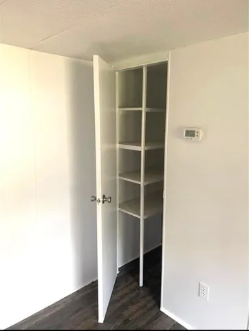 a view of walk in closet with empty racks