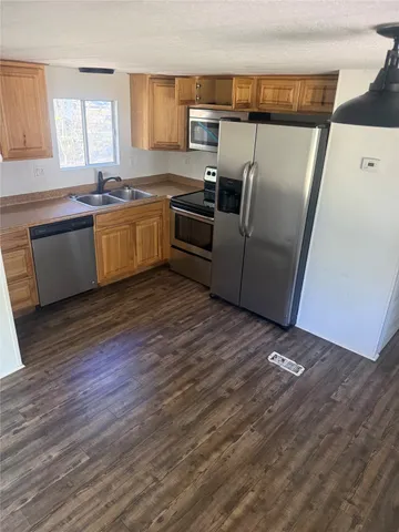 a kitchen with granite countertop a sink and refrigerator