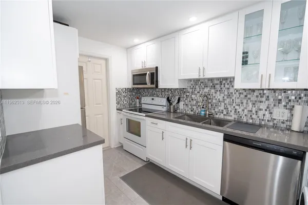 a kitchen with stainless steel appliances granite countertop a sink and a stove