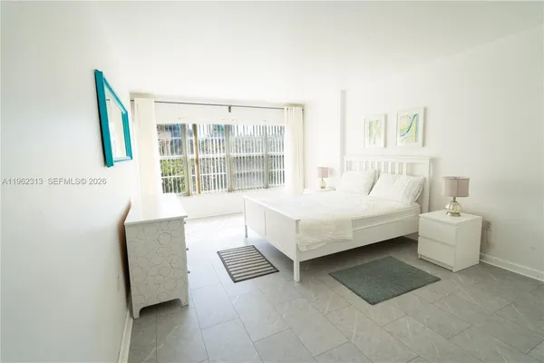 a bedroom with a bed and a large window