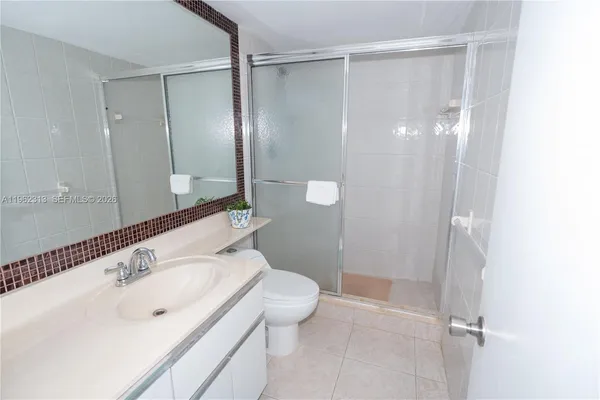 a bathroom with a shower sink vanity and toilet