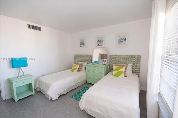 a bedroom with two beds and painting on the wall