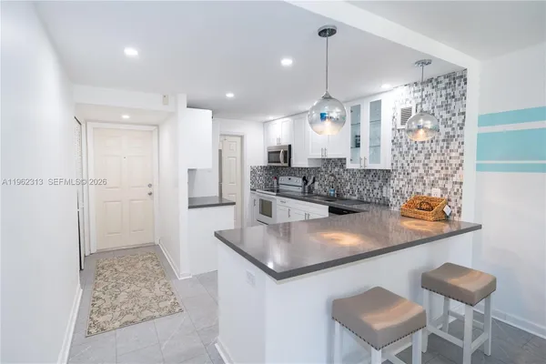 a kitchen with stainless steel appliances granite countertop a sink and a refrigerator