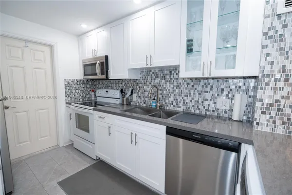 a kitchen with stainless steel appliances granite countertop a sink stove and cabinets