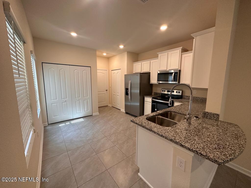 256 Talulla Trail St. Augustine, FL 32095 - Photo 3 of 12 a kitchen with stainless steel appliances granite countertop a refrigerator and a sink