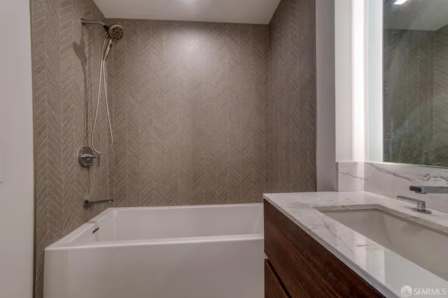 a bathroom with a granite countertop sink a toilet and shower