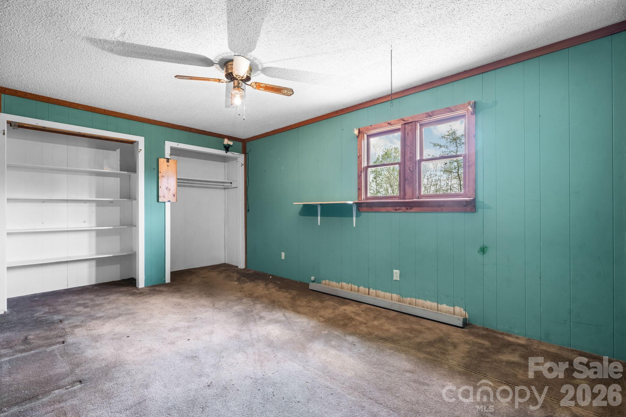 103 Bernice Street Marion, NC 28752 - Photo 26 of 48 an empty room with a ceiling fan and window