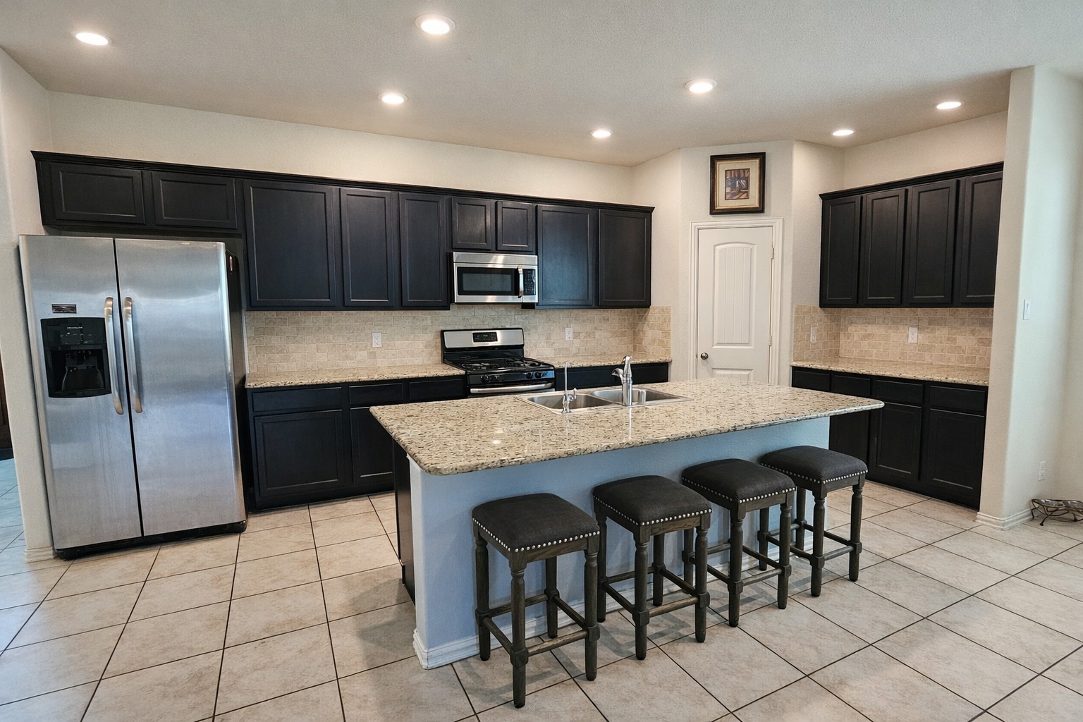 16410 Regal Exeter Drive Houston, TX 77073 - Photo 4 of 21 a kitchen with granite countertop a refrigerator and a stove top oven