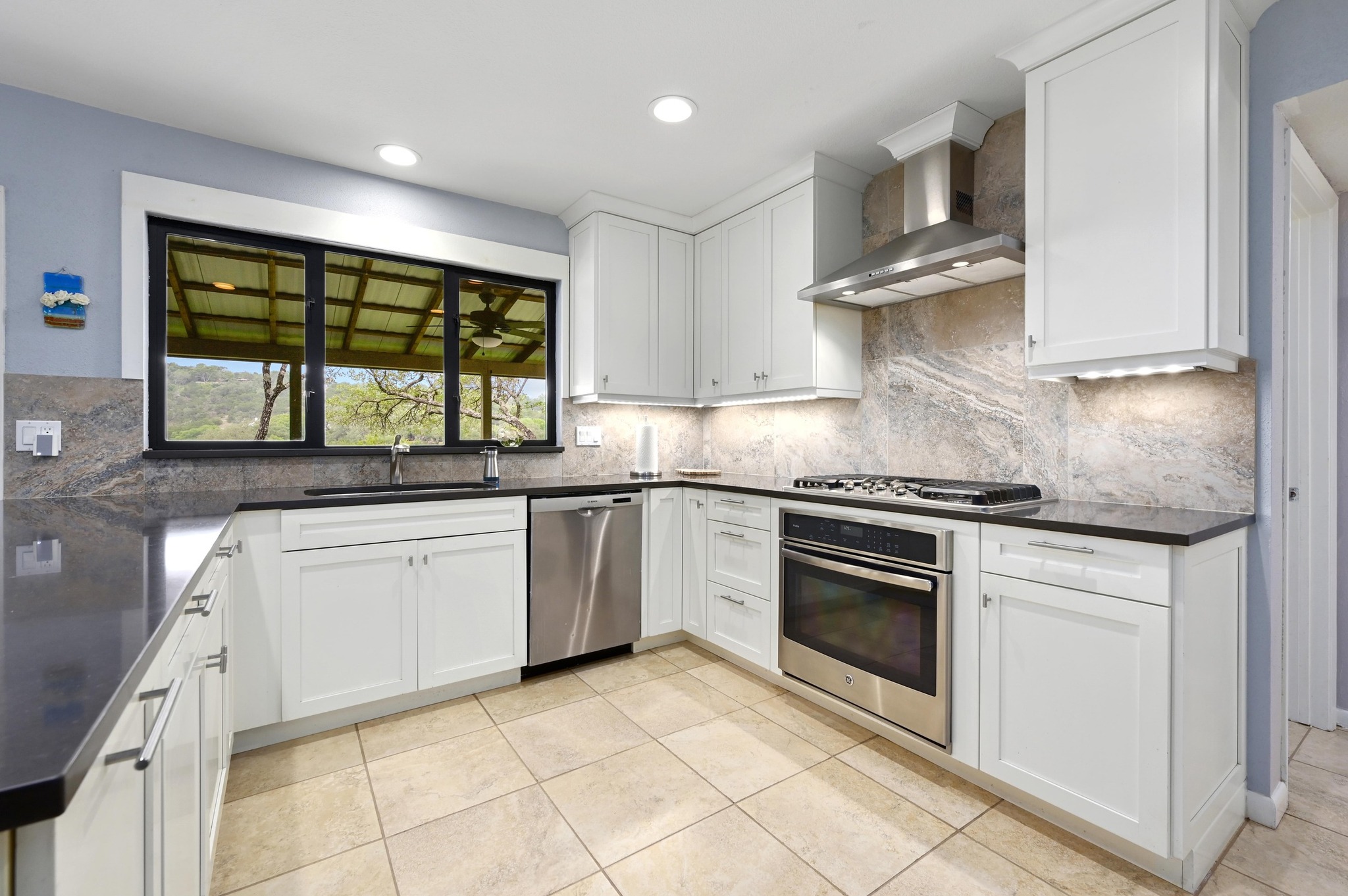 2009 South Oak Canyon Road Austin, TX 78746 - Photo 14 of 37 a kitchen with granite countertop a stove sink and microwave
