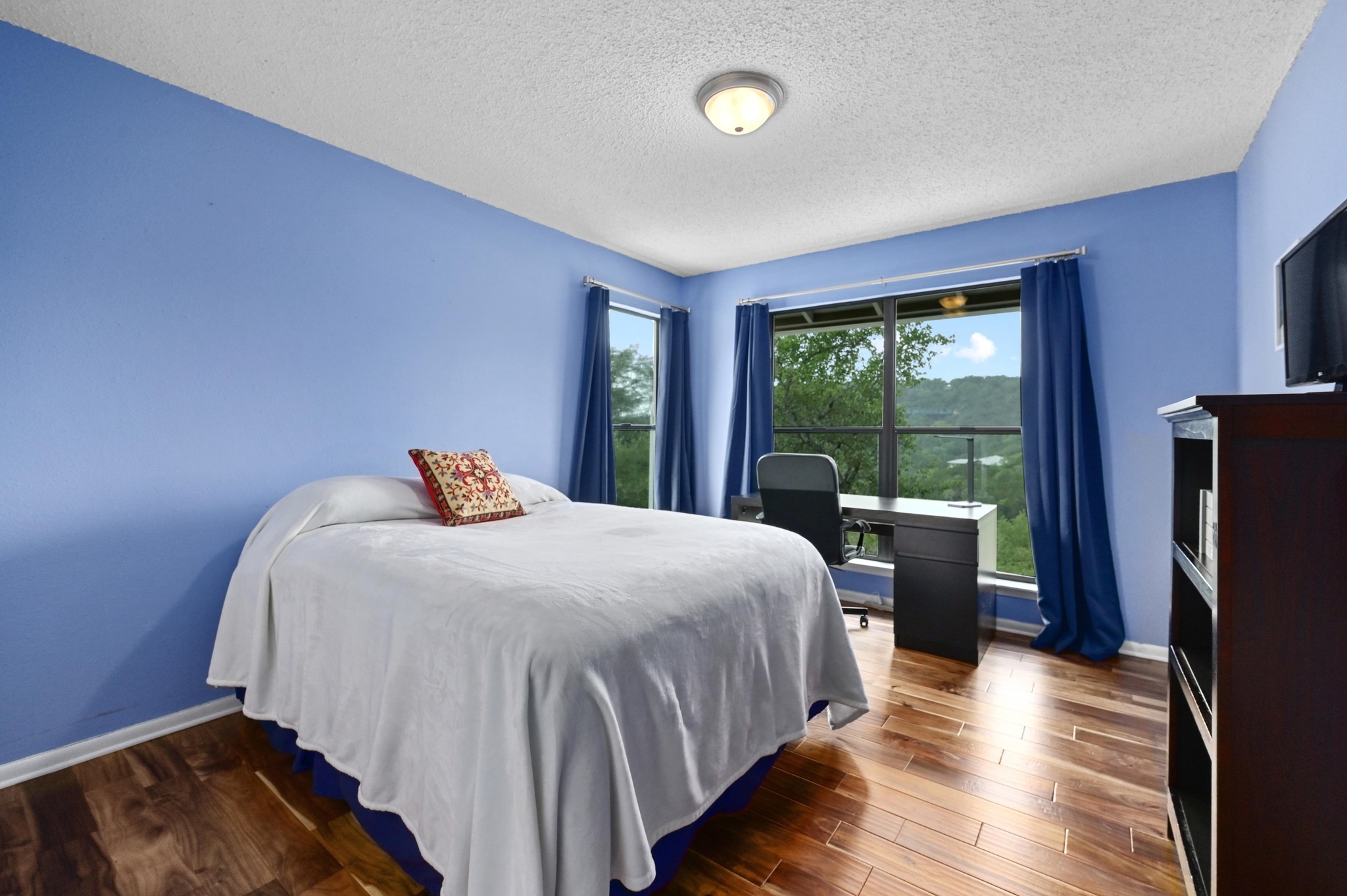 2009 South Oak Canyon Road Austin, TX 78746 - Photo 25 of 37 a bed sitting in a bedroom next to a window