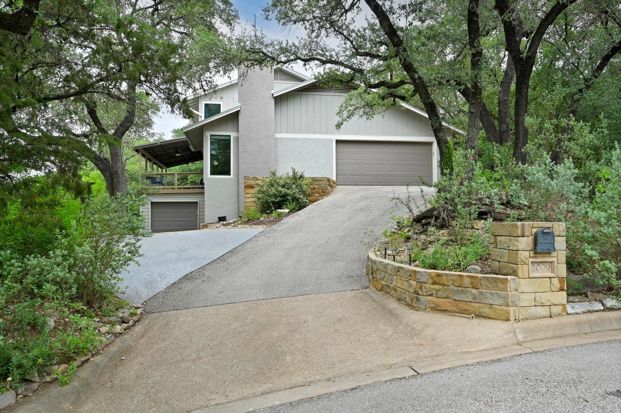 2009 South Oak Canyon Road Austin, TX 78746 - Photo 3 of 37 front view of a house with a yard and potted plants