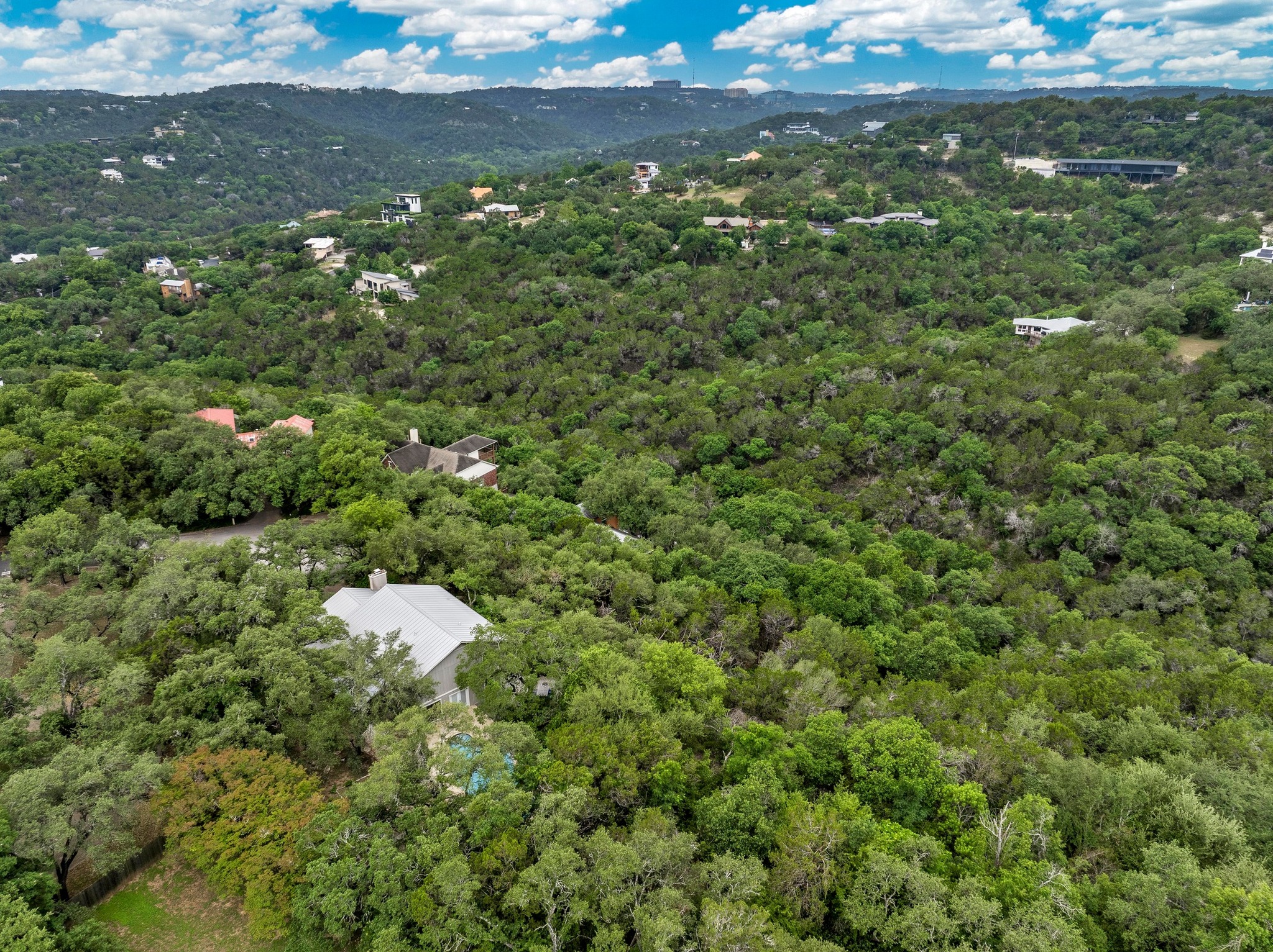 2009 South Oak Canyon Road Austin, TX 78746 - Photo 34 of 37 a view of a house with a lush green forest