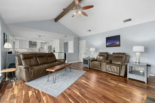 a living room with furniture a rug and a chandelier