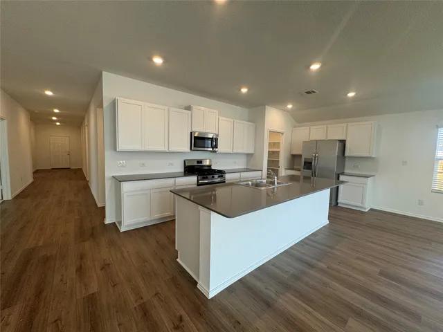 a view of kitchen with wooden floor and electronic appliances