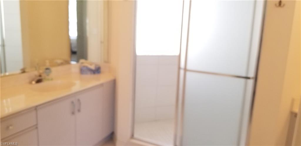 81 Silver Oaks Circle, Unit 7204 Naples, FL 34119 - Photo 21 of 33 a bathroom with a double vanity sink and a mirror