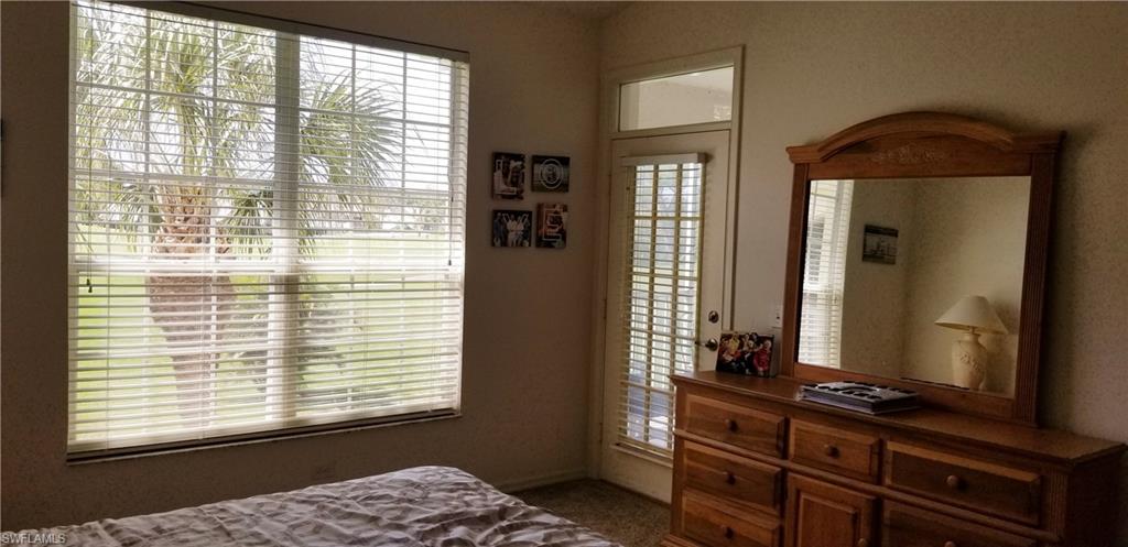 81 Silver Oaks Circle, Unit 7204 Naples, FL 34119 - Photo 22 of 33 a bedroom with a bed and a dresser next to a window