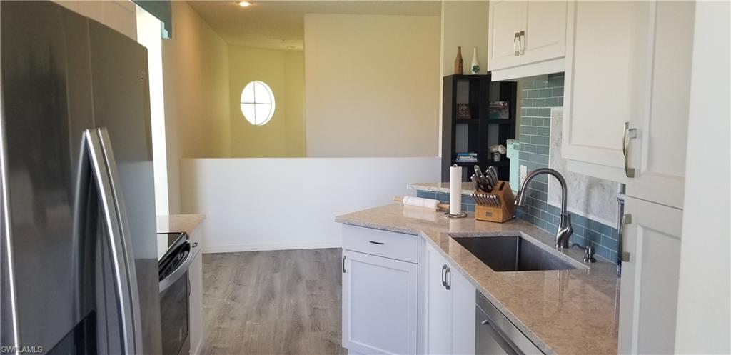 81 Silver Oaks Circle, Unit 7204 Naples, FL 34119 - Photo 8 of 33 a kitchen with stainless steel appliances granite countertop a sink and a refrigerator