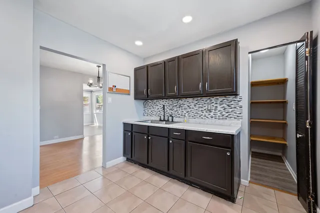 a kitchen with granite countertop a refrigerator and a stove top oven