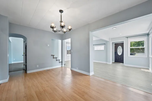 a view of a livingroom with wooden floor and a chandelier