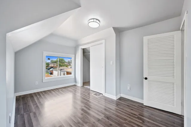 an empty room with wooden floor and window
