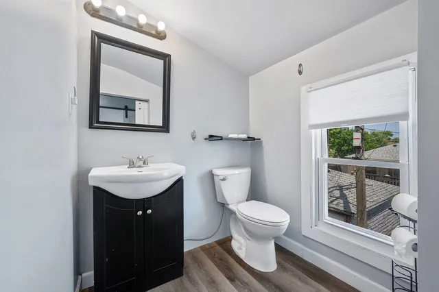 a bathroom with a toilet a sink and mirror