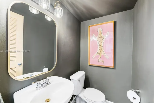 a bathroom with a toilet sink and mirror