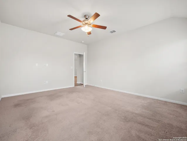 an empty room with closet and ceiling fan