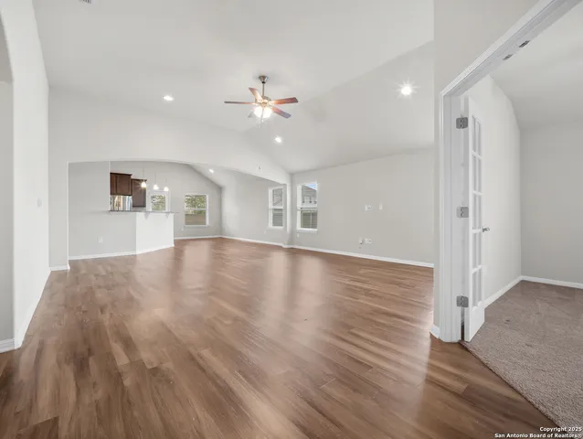 a view of empty room with wooden floor and ceiling fan