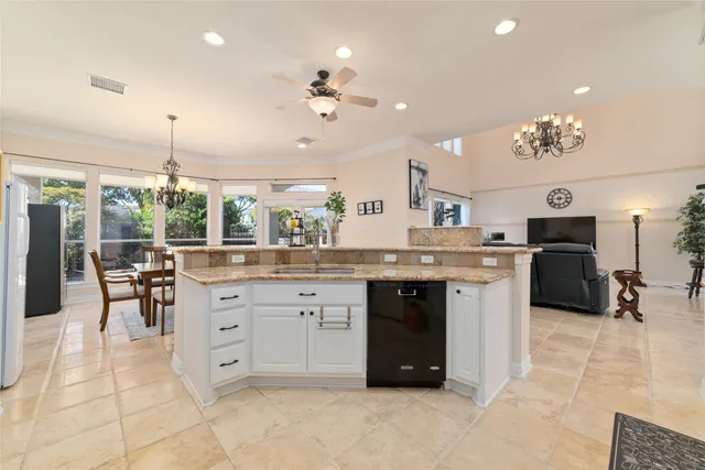 a kitchen with granite countertop a sink cabinets and stainless steel appliances