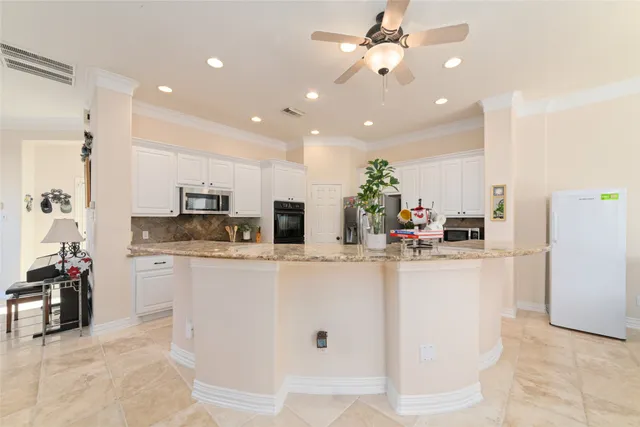 a kitchen with kitchen island a counter top space appliances and cabinets