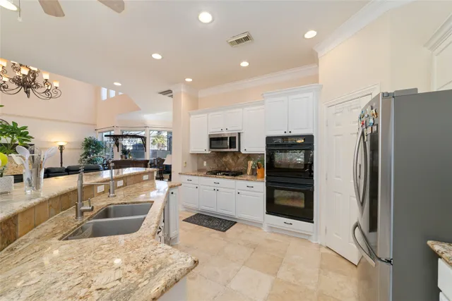 a kitchen with stainless steel appliances granite countertop a refrigerator and a sink