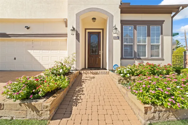 a front view of a house with a lot of flower and flowers