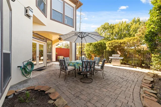 a view of a patio with table and chairs under an umbrella