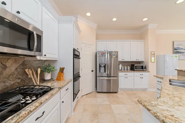a kitchen with stainless steel appliances granite countertop a stove and a refrigerator