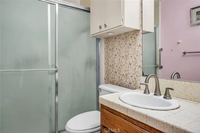 a bathroom with a granite countertop sink toilet and shower