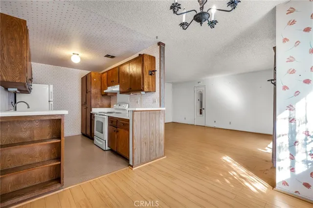 a kitchen with a stove cabinets and a wooden floor