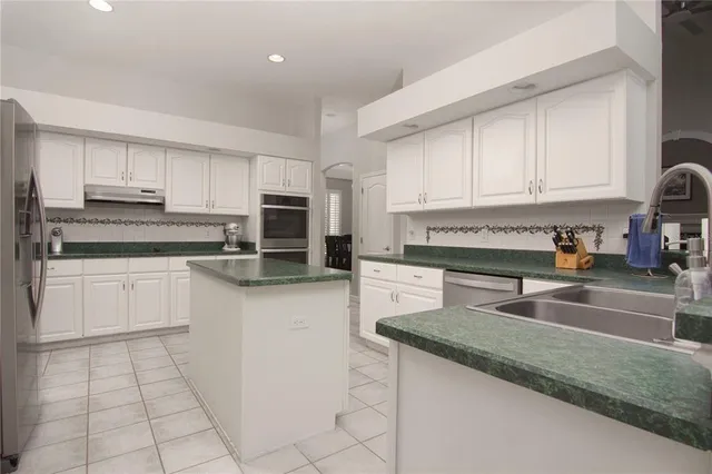 a kitchen with granite countertop a sink stove and cabinets