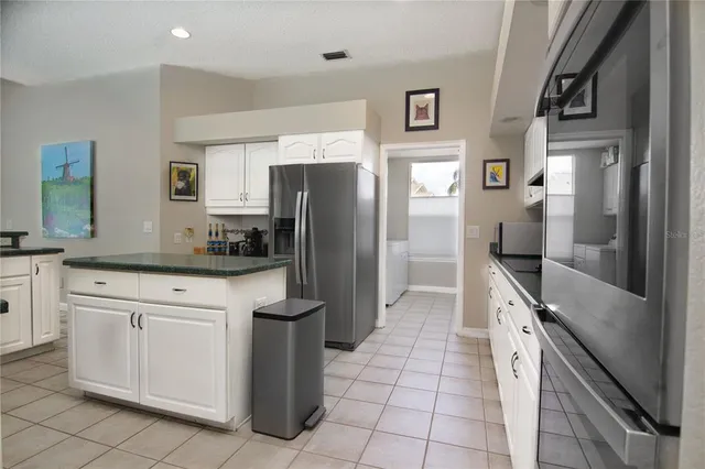 a kitchen with stainless steel appliances a refrigerator sink and cabinets