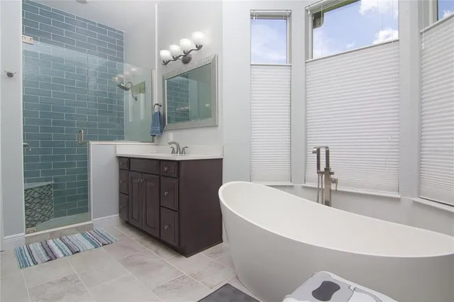 a bathroom with a tub sink and mirror