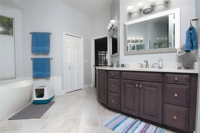 a spacious bathroom with a sink a mirror and a bathtub