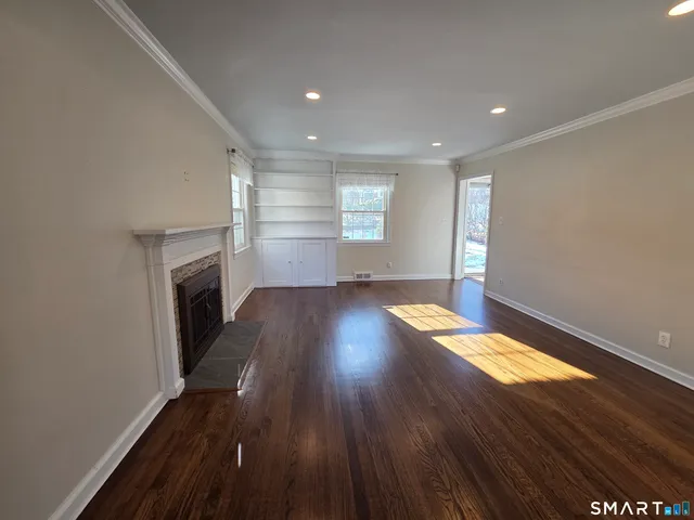 an empty room with wooden floor and fireplace