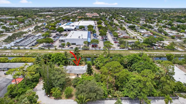 an aerial view of residential houses with outdoor space and trees