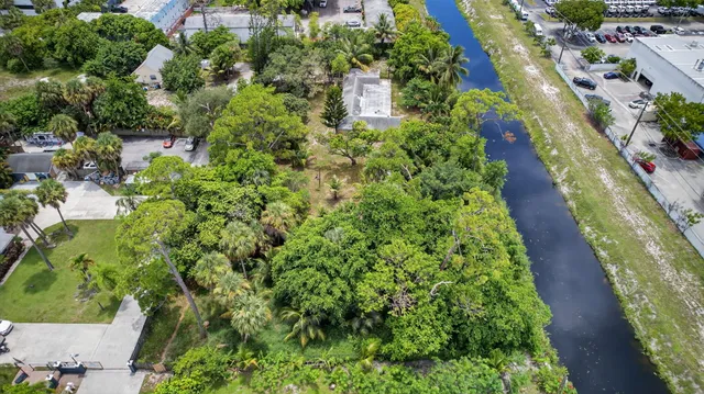an aerial view of residential house with outdoor space and trees all around