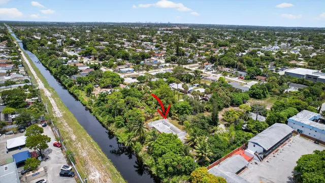 an aerial view of residential houses with outdoor space and trees